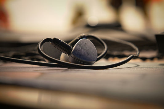 Set of in ear monitors sitting on light surface with neutral gray-white tones