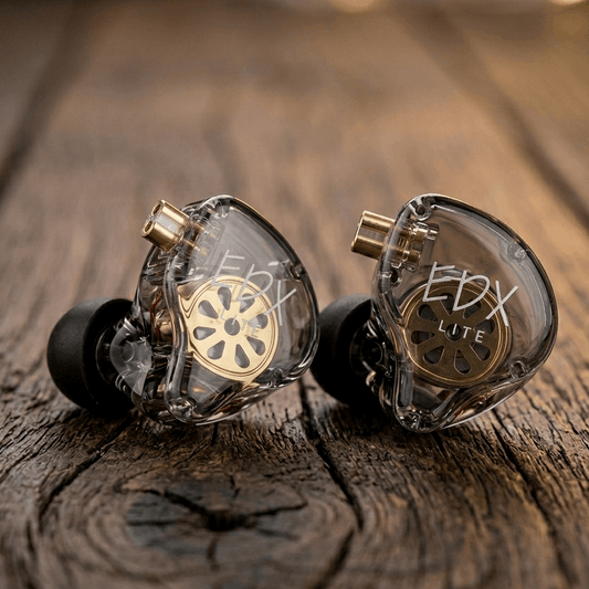 KZ EDX LITE in-ear monitors with transparent housing and gold accents, displayed on a wooden surface.