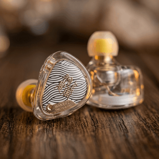 TangZu Waner 2 earphones with a clear housing and intricate design, showcasing a unique aesthetic on a wooden surface.
