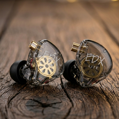 KZ EDX LITE in-ear monitors with transparent housing and gold accents, displayed on a wooden surface.