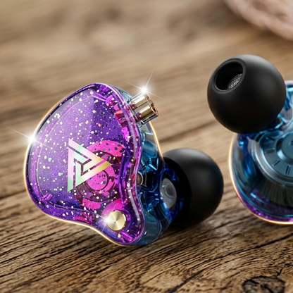 QKZ AK6 Pro in-ear monitors with purple glitter housing and black silicone ear tips on a wooden surface.