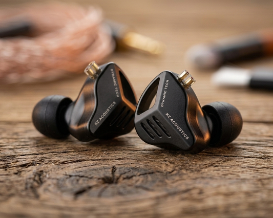 KZ ZVX in-ear monitors with dynamic drivers, featuring a sleek black design and ear tips, resting on a wooden surface.