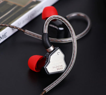 Salnotes Zero earphones with metallic casing and red silicone ear tips on a black surface.