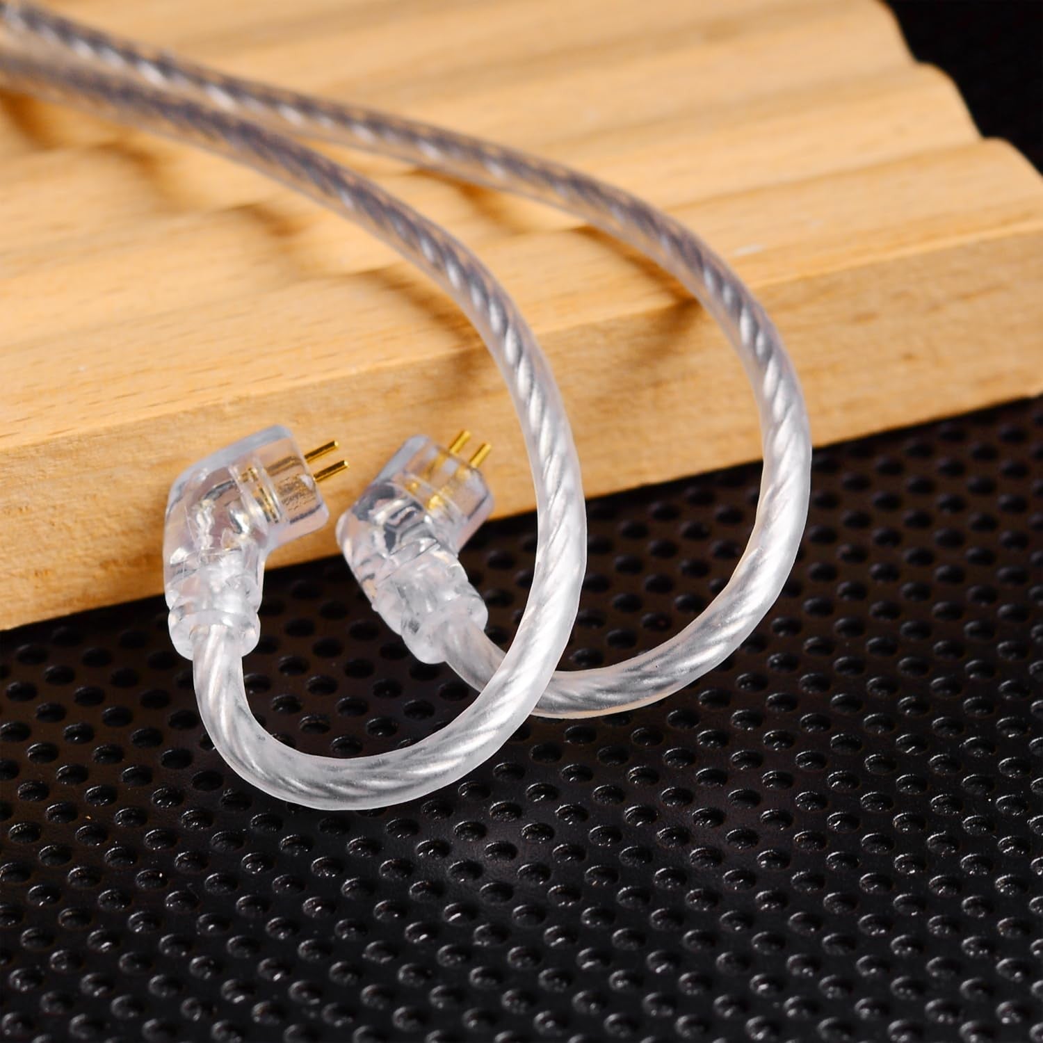 Clear, flexible IEM cable from THE VOLTRAY VAULT, featuring two connectors and a braided design on a textured surface.